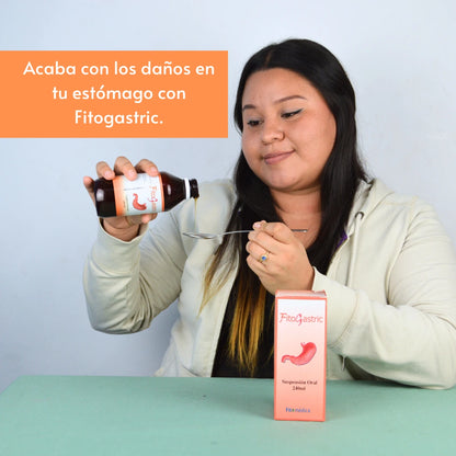 Mujer sosteniendo un frasco de Fitogastric, mientras vierte medicamento en una cuchara. A su lado se muestra la caja del medicamento. En la parte superior un texto que dice: 'Acaba con los daños en tu estómago con Fitogastric'.  